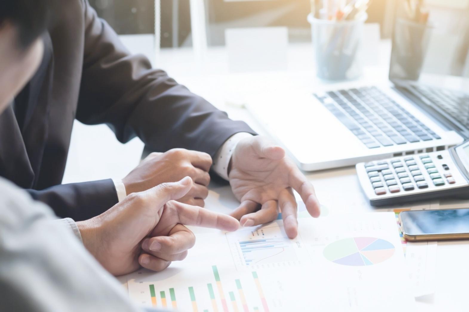 Analyse de documents financiers sur un bureau avec graphiques et calculatrice